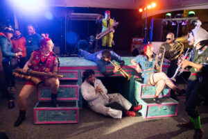 members of bedlam brass sitting on a giant desk